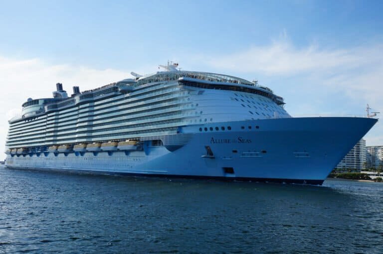 Large cruise ship Allure of the Seas sailing in port with clear blue sky.