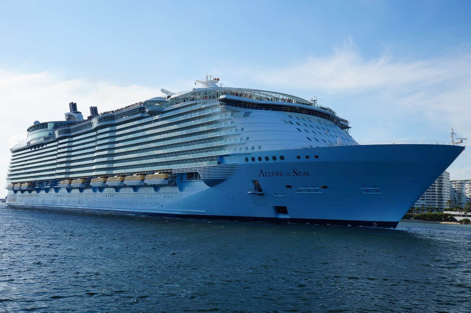 Large cruise ship Allure of the Seas sailing in port with clear blue sky.
