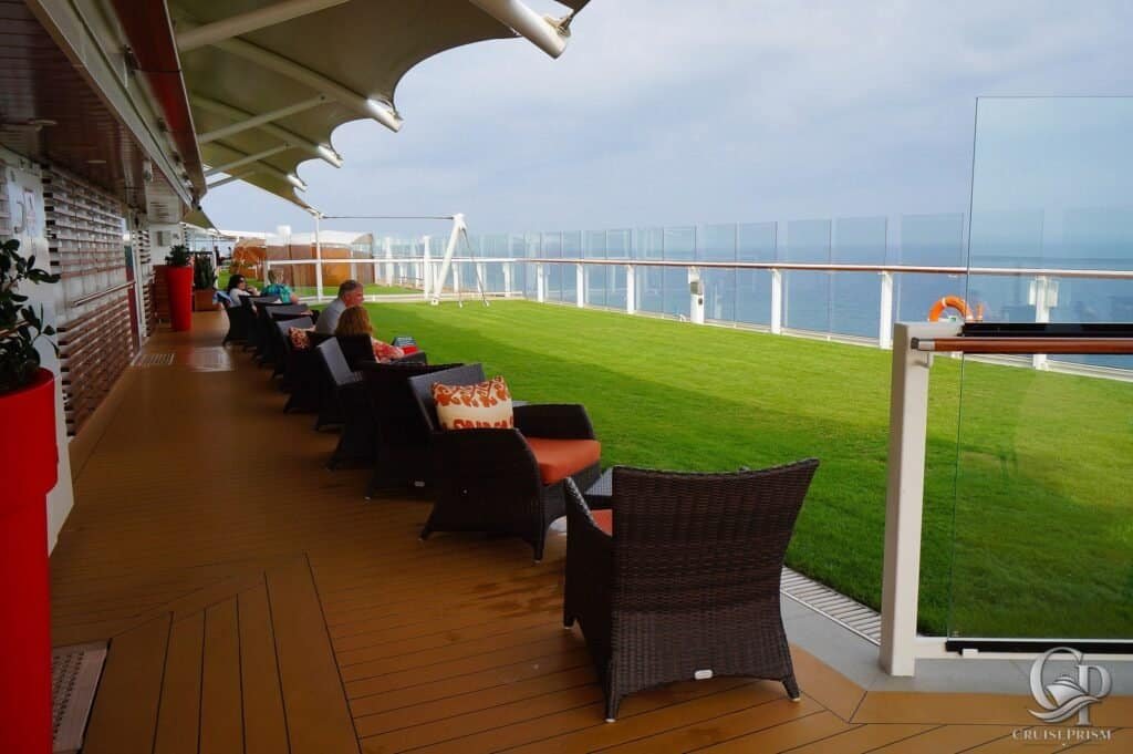 Celebrity silhouette deck lounge with chairs and glass railing overlooking the ocean.