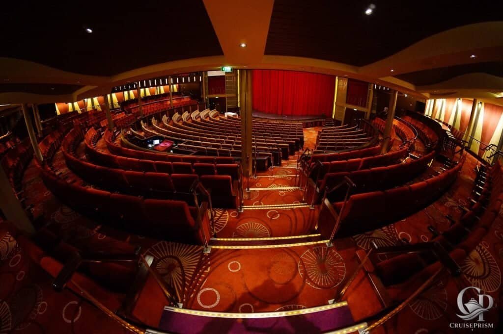 Theater on Celebrity silhouette cruise ship with red curtains and plush seating for entertainment.