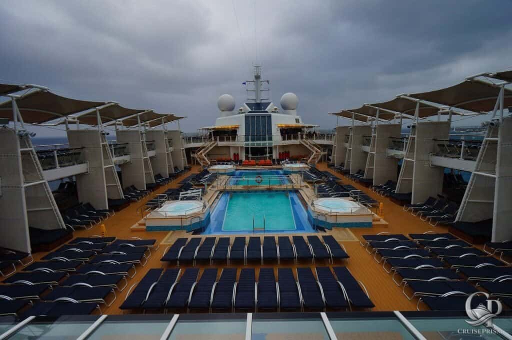 Celebrity Silhouette cruise ship pool deck with sun loungers and shaded lounging areas.
