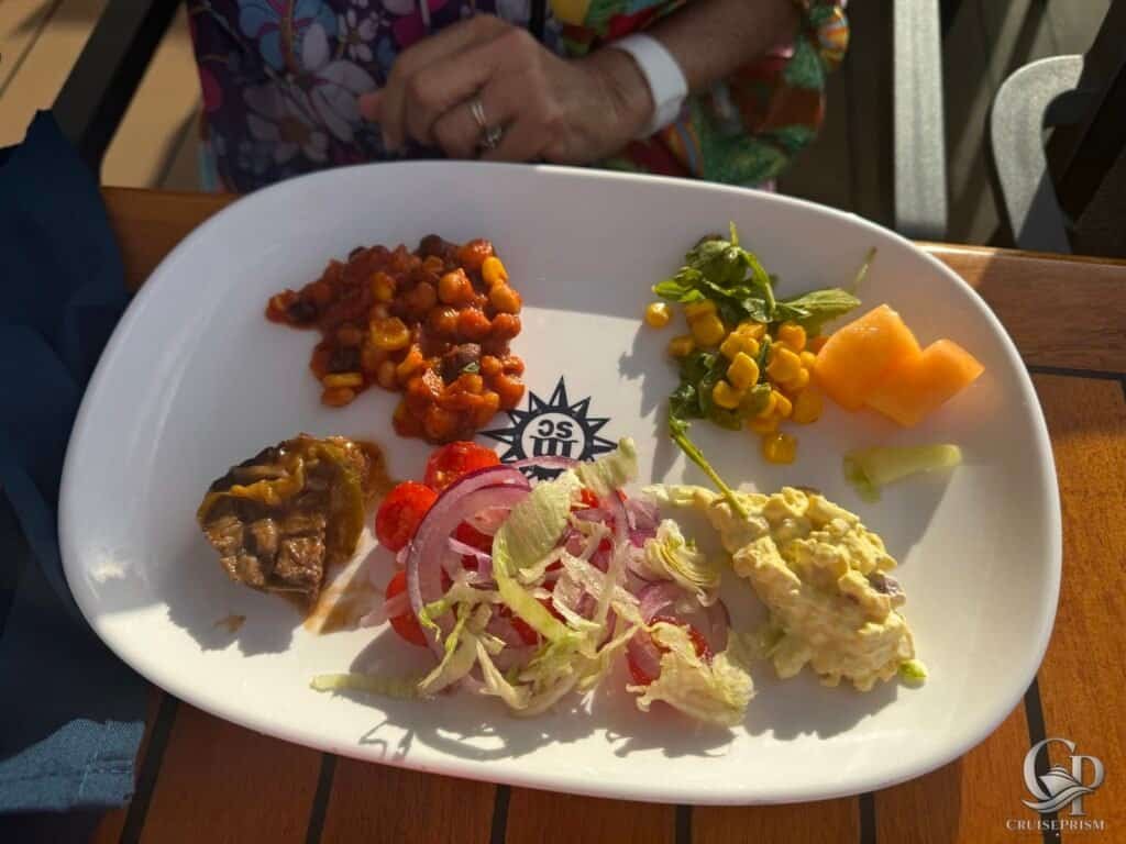 Assorted fresh salads and side dishes on a cruise ship dining plate.