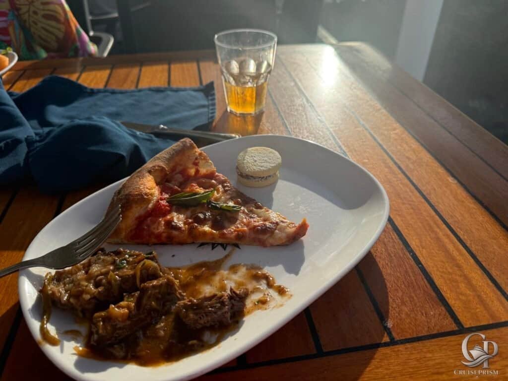 Pizza slice with cheese and basil, beef stew with vegetables on a white plate.