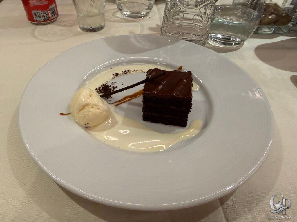 Chocolate cake with creamy ice cream and decorative sauce.