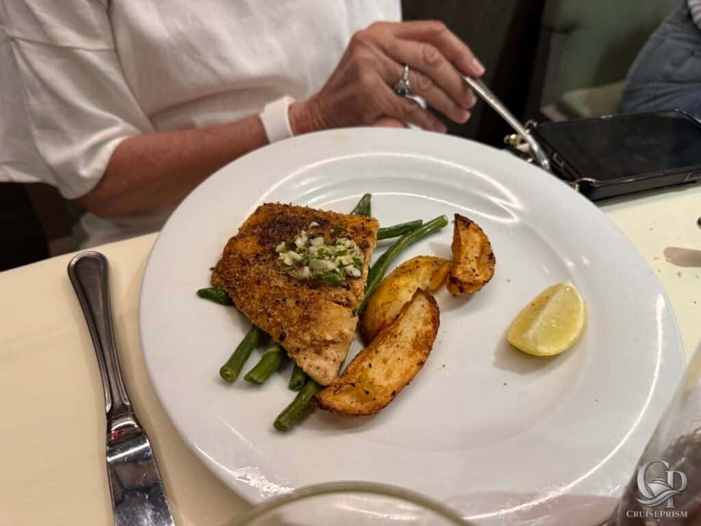 Delicious grilled fish served with green beans, roasted potatoes, and a lemon wedge, perfect for a c.