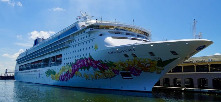 Norwegian Sky cruise ship docked at port with vibrant hull design.
