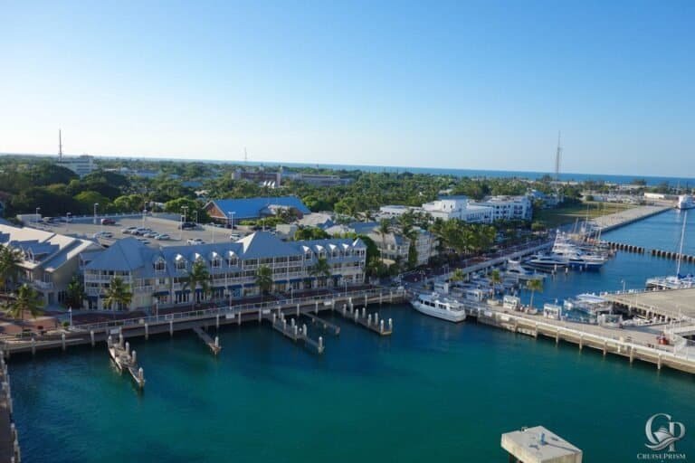 Marina with yachts, waterfront buildings, and scenic coastal views.