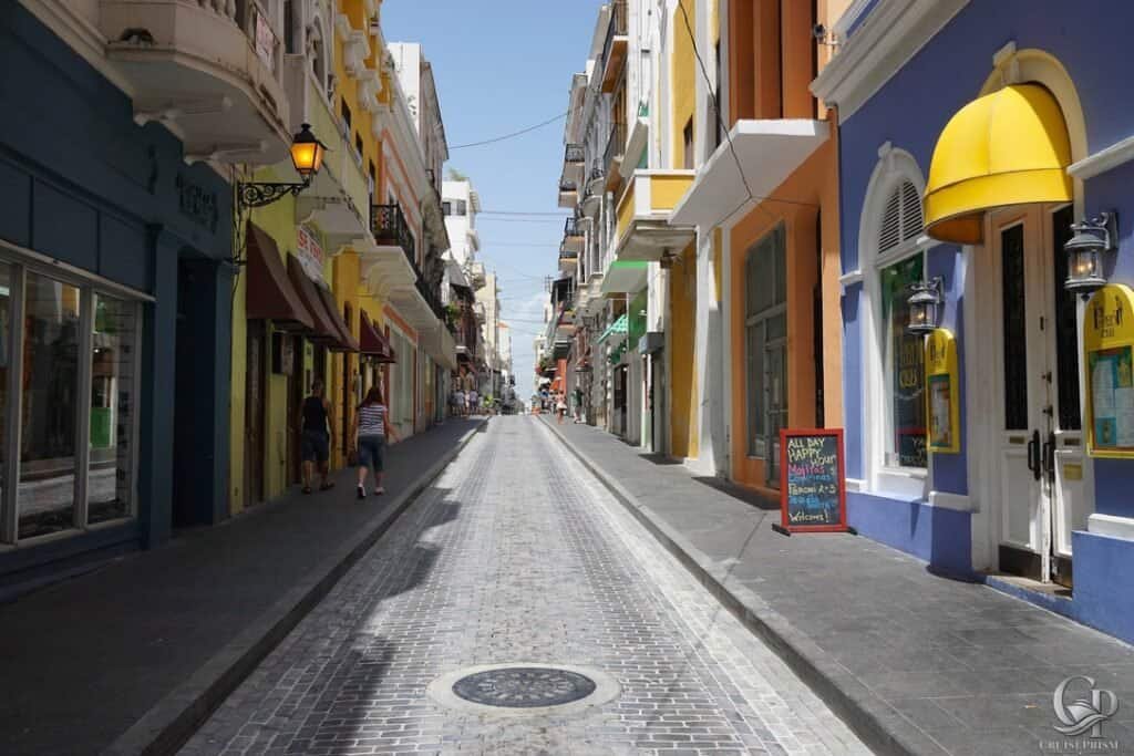 Vibrant city street with colorful buildings, cobblestone pavement, and lively atmosphere, perfect fo.