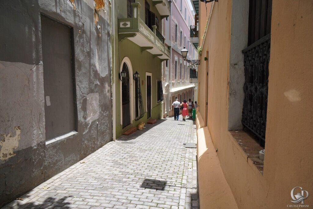 Alleyway in Europe with cobblestones, narrow street, and vibrant building facades.